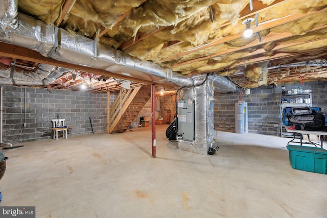 unfinished below grade area with electric water heater, stairway, concrete block wall, and heating unit