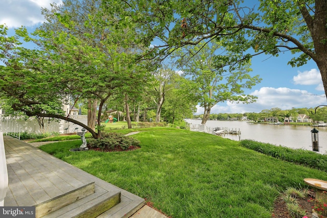 view of green lawn with a water view