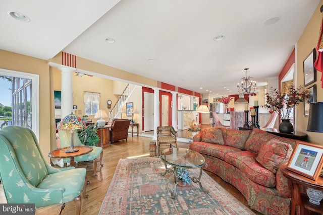 living room with decorative columns, wood finished floors, a chandelier, and recessed lighting