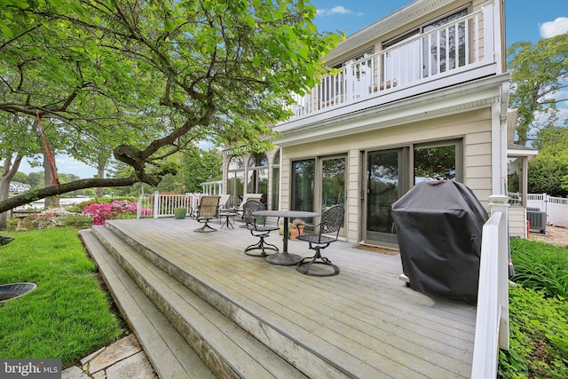 wooden terrace with outdoor dining space and area for grilling