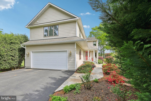 traditional home featuring an attached garage, asphalt driveway, and a porch