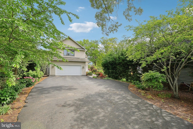 view of front of property with asphalt driveway and a garage