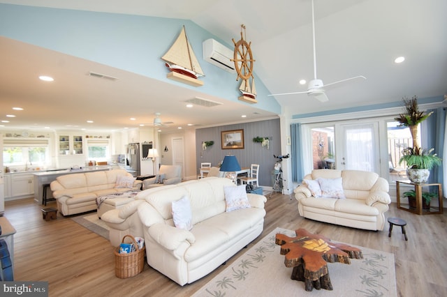 living room with a ceiling fan, a wall mounted air conditioner, visible vents, and high vaulted ceiling