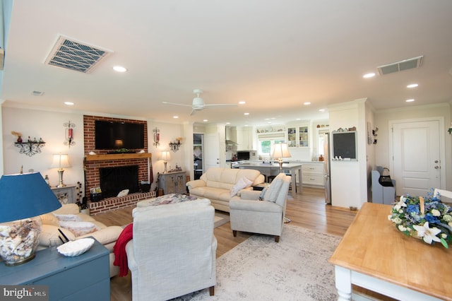 living area with ornamental molding, a fireplace, and visible vents