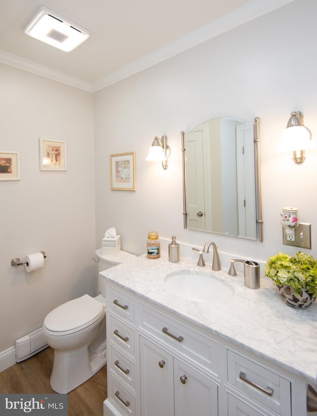 bathroom featuring crown molding, toilet, wood finished floors, and vanity