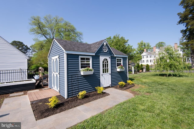 view of outdoor structure featuring fence and an outbuilding