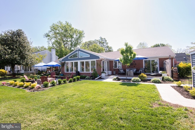 back of property with a yard, brick siding, outdoor lounge area, fence, and a patio