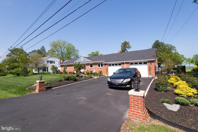 view of front facade with brick siding, aphalt driveway, a front lawn, and a garage