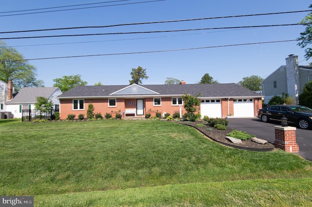 ranch-style house with an attached garage, brick siding, driveway, and a front yard