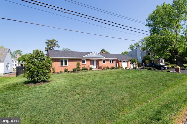 ranch-style house with a front lawn, brick siding, an attached garage, and fence