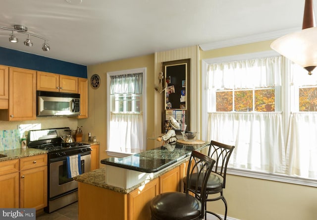 kitchen featuring stainless steel appliances, dark stone countertops, dark tile patterned floors, and backsplash