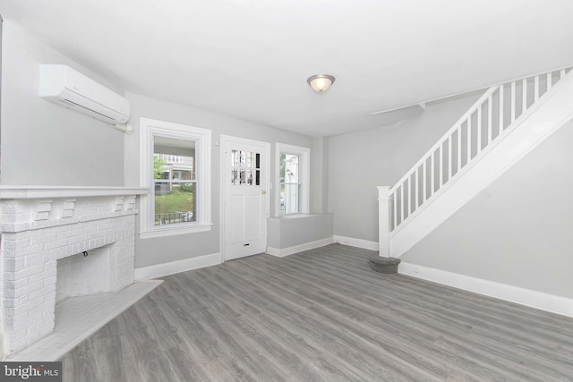 foyer entrance with stairway, baseboards, and a wall mounted AC