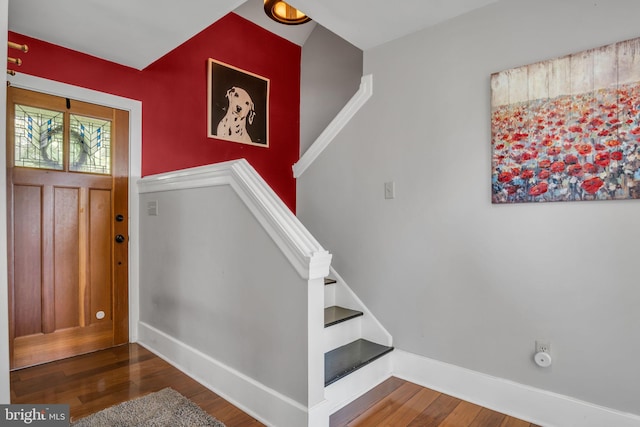 entryway with wood finished floors, stairway, and baseboards