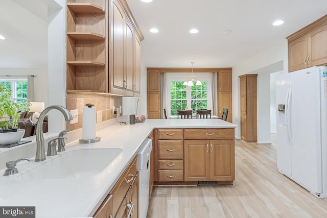 kitchen with a peninsula, a sink, open shelves, white appliances, and recessed lighting