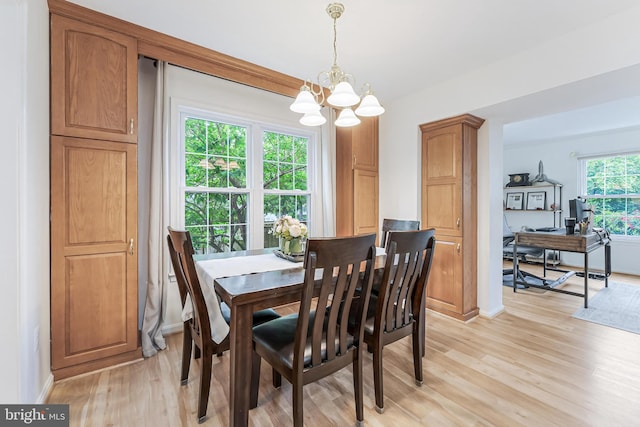 dining space with baseboards, an inviting chandelier, and light wood-style flooring
