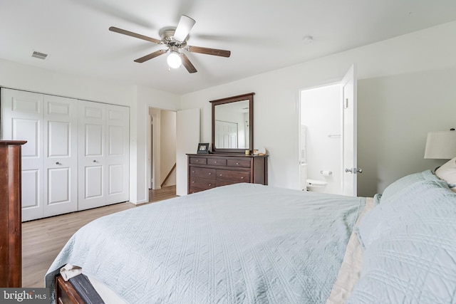 bedroom with a ceiling fan, a closet, ensuite bathroom, visible vents, and wood finished floors