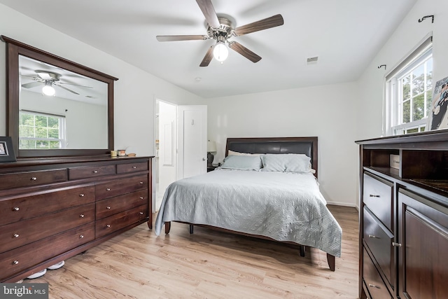 bedroom featuring light wood finished floors, visible vents, and a ceiling fan
