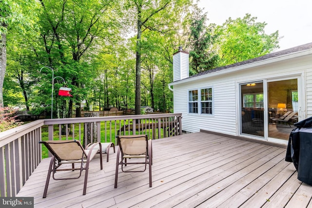 wooden terrace with a fenced backyard