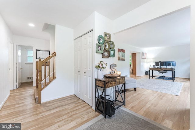 hall with light wood-type flooring, stairway, baseboards, visible vents, and recessed lighting