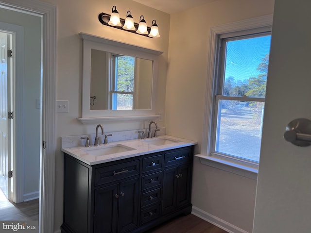 711 Tuckahoe Rd, Vineland, NJ 08360 - bathroom with baseboards, double vanity, a sink, and wood finished floors