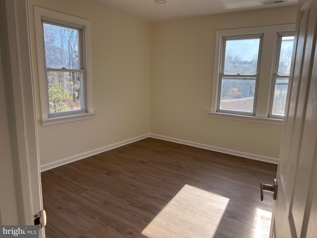 711 Tuckahoe Rd, Vineland, NJ 08360 - unfurnished room featuring dark wood-style flooring, baseboards, and a healthy amount of sunlight