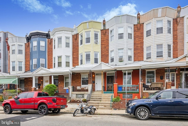 townhome / multi-family property with a porch and cooling unit
