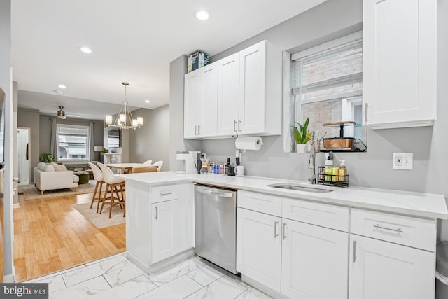 kitchen with recessed lighting, stainless steel dishwasher, a sink, light countertops, and white cabinets
