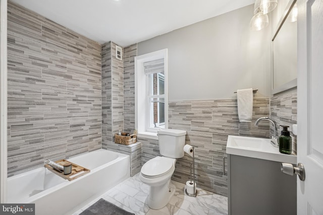 bathroom with tile walls, toilet, marble finish floor, vanity, and a tub