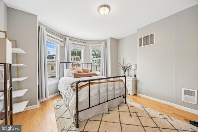 bedroom featuring visible vents, wood finished floors, and baseboards
