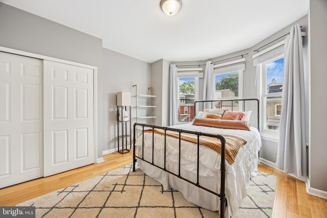 bedroom with a closet, wood finished floors, and baseboards