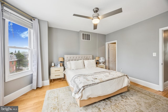 bedroom featuring baseboards, ceiling fan, light wood finished floors, and visible vents