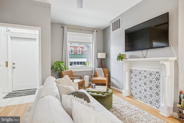 living area featuring visible vents and wood finished floors