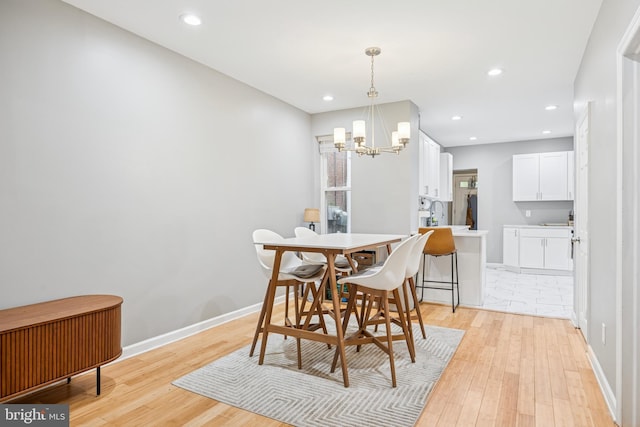 dining area featuring a chandelier, baseboards, light wood-style flooring, and recessed lighting