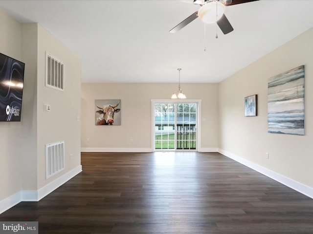 unfurnished dining area featuring dark wood-type flooring, a ceiling fan, baseboards, and a chandelier