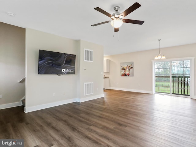 unfurnished living room with wood finished floors, a ceiling fan, a chandelier, and baseboards