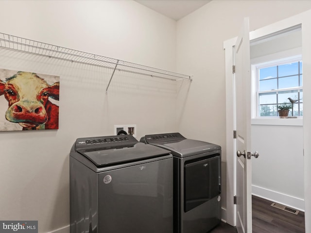 laundry room with independent washer and dryer, dark wood-style flooring, and baseboards