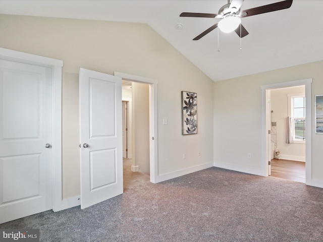 unfurnished bedroom featuring carpet, lofted ceiling, baseboards, connected bathroom, and ceiling fan