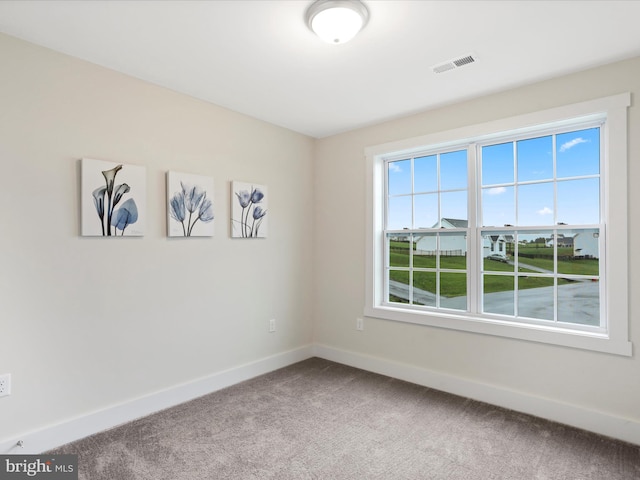 carpeted empty room featuring baseboards