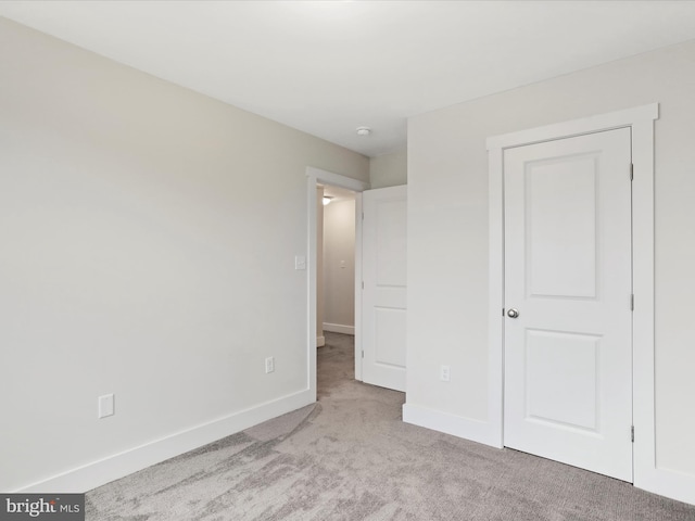 unfurnished bedroom featuring carpet and baseboards