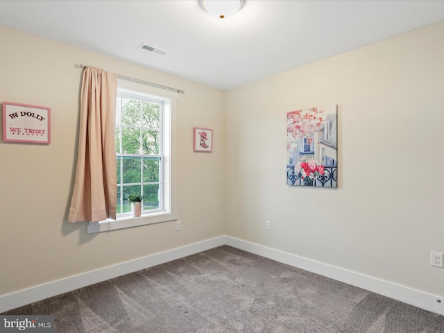 carpeted spare room featuring baseboards