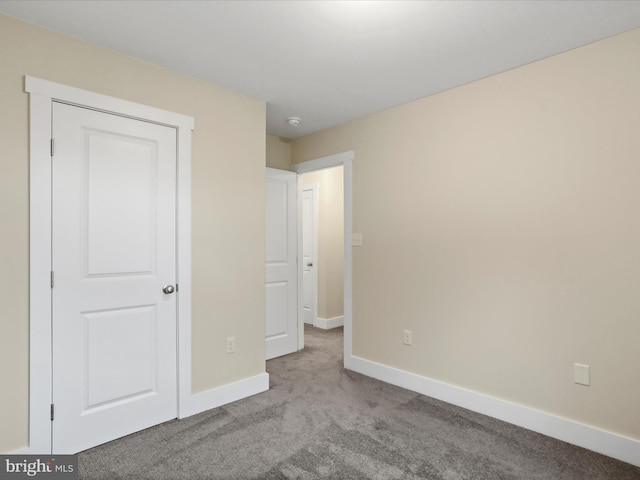 unfurnished bedroom with carpet floors and baseboards
