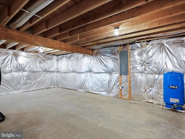 unfinished basement with a water pressure tank and electric panel