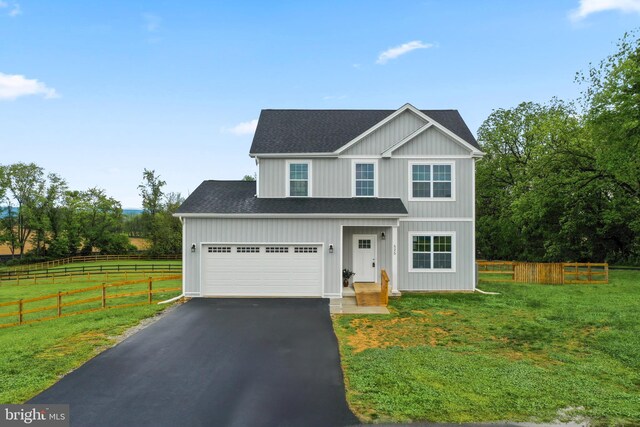 traditional-style home featuring asphalt driveway and a shingled roof