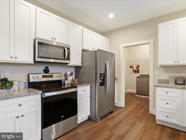 kitchen featuring appliances with stainless steel finishes, washer / dryer, white cabinets, and recessed lighting