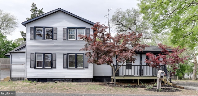 view of front facade with a deck and fence