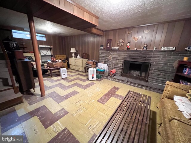 living area with wood walls and a fireplace with raised hearth