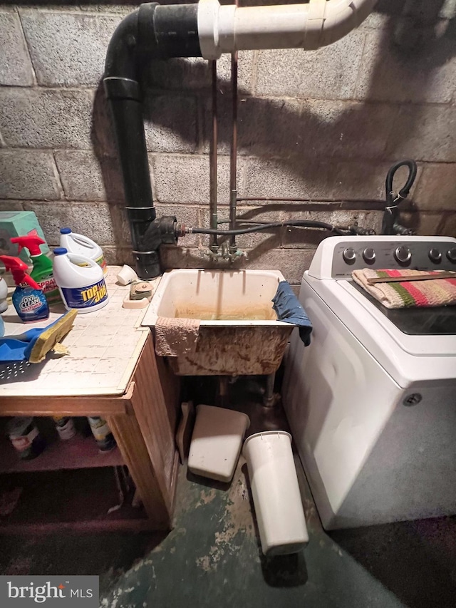 interior details featuring washer / clothes dryer, concrete flooring, and concrete block wall