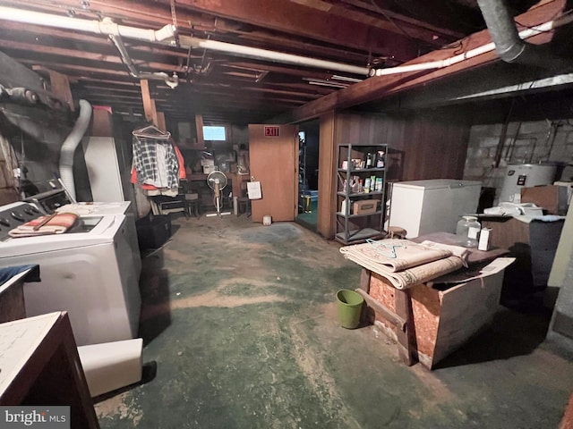 unfinished below grade area featuring electric water heater, refrigerator, and washer and dryer