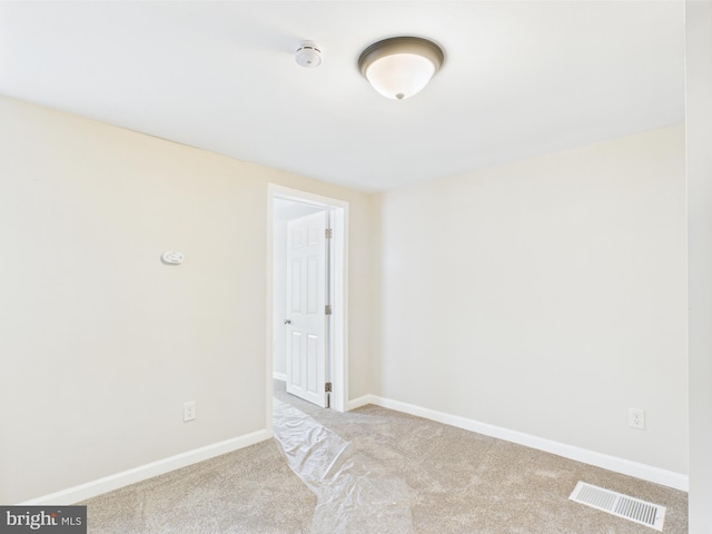 carpeted spare room with baseboards and visible vents