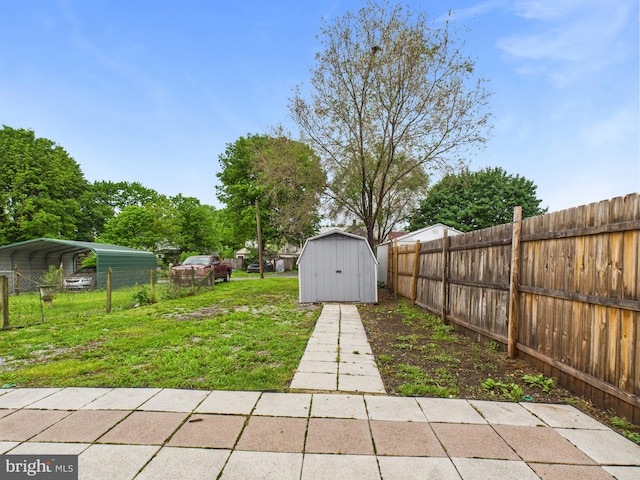view of yard featuring a storage shed, a carport, an outbuilding, and a fenced backyard